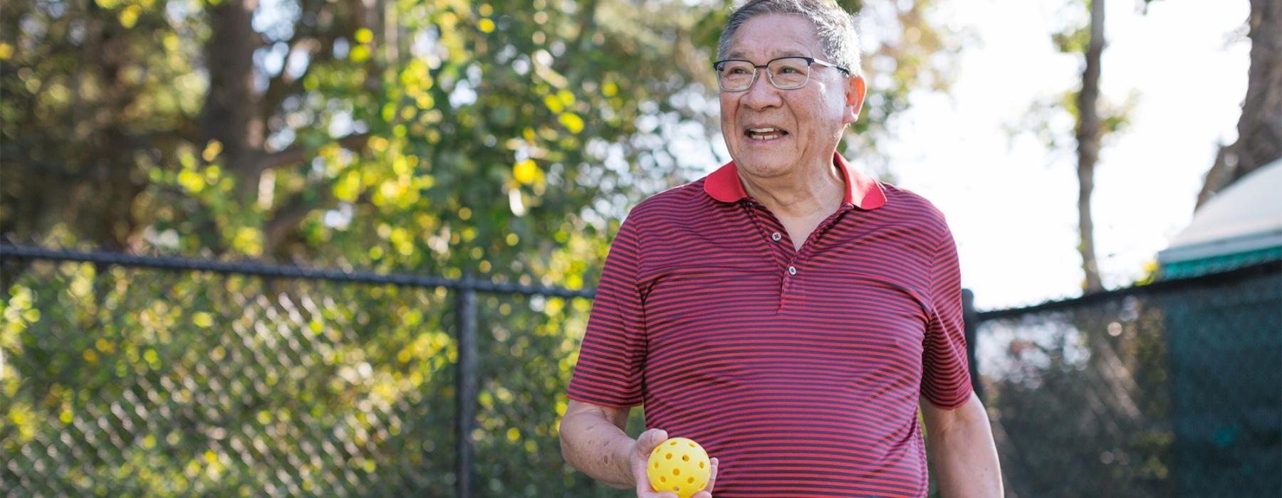 a man holding a Pickleball racket